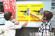 「日米合同演習反対あいば野大集会」のポスターを貼り出す人たち写真