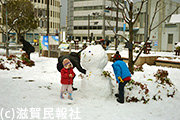大津駅前で雪だるまを作る親子写真
