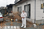 2017年に一時帰宅した双葉町の自宅前に立つ小川氏写真